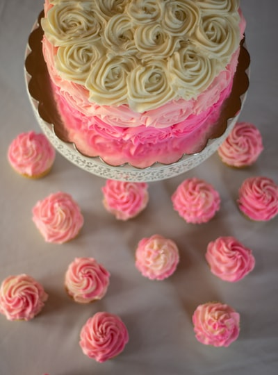 Pink and yellow cupcakes, topped with pink icing
